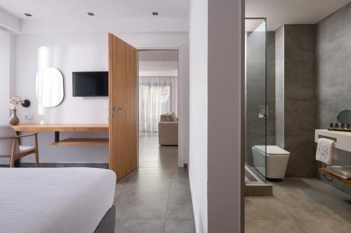 ein Schlafzimmer mit Bett und Schreibtisch sowie ein Badezimmer in der Unterkunft The Oak Hotel in Keramotí