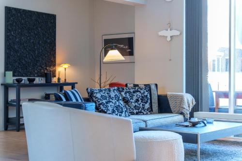 a living room with a blue couch and a table at Modern Apartment with Balcony near Tivoli & Metro in Copenhagen