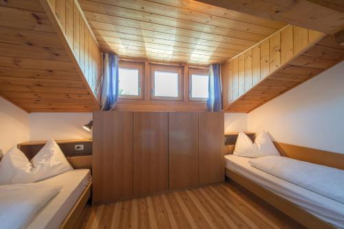 two beds in a small room with a window at Garni-Residence Villa Paul in Nova Ponente