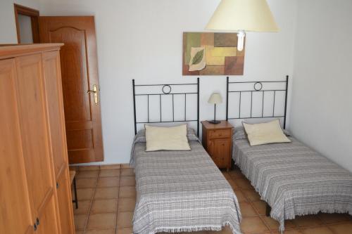 two beds in a small room with a lamp at Can Llorach in Sant Jaume d'Enveja