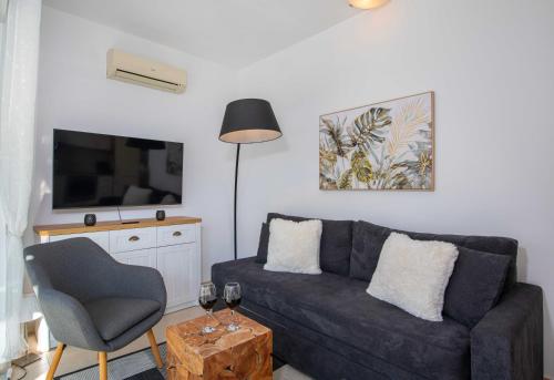a living room with a couch and a chair at Outstanding Apartment in an Unique Aegean Inspired Settlement in Agia Triada