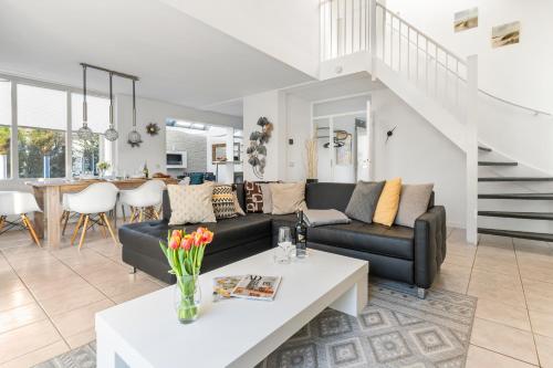 a living room with a couch and a table at Villa Beach & Golf in Julianadorp