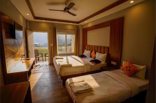 a hotel room with two beds and a balcony at Ganga villa in Jāmb