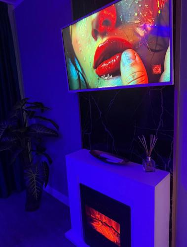 a living room with a tv and a fireplace at AFI Discret Jacuzzi in Bucharest