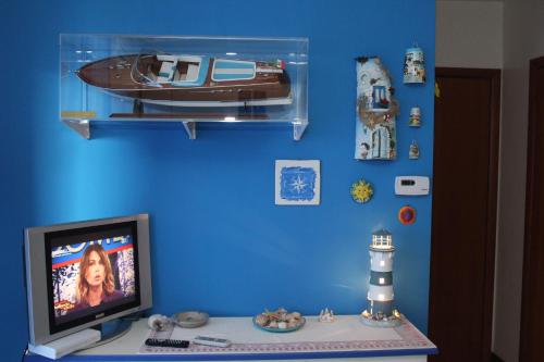 a room with a tv and a toy boat on a blue wall at Casina Carina Carina in Nettuno