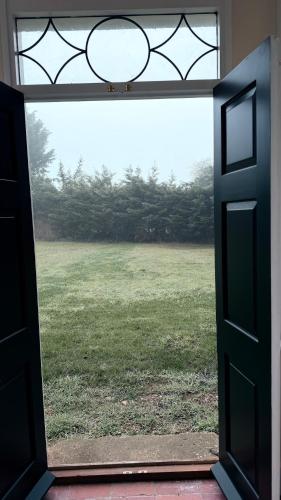 an open door with a view of a field at Superb Spacious Farm House in Henley on Thames