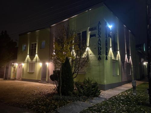 a building with lights on the side of it at night at Vila Alexandra 2025 in Bačka Topola