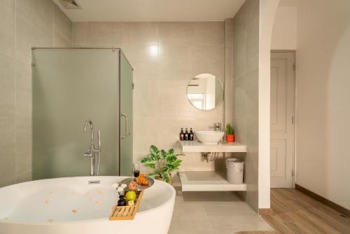 a bathroom with a bath tub and a sink at Chạm's Hotel & Homestay in Ho Chi Minh City
