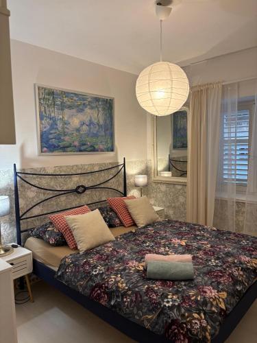 a bedroom with a large bed and a chandelier at LEGRAND Town Center in Makarska