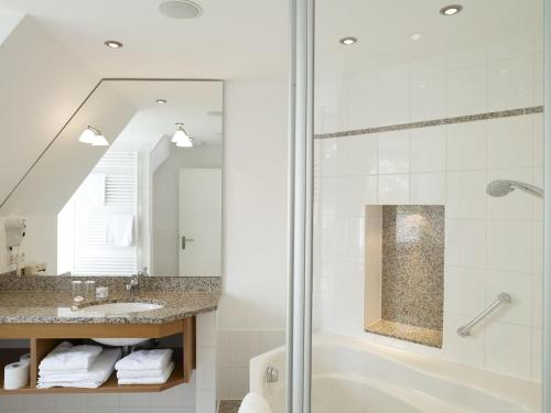 a bathroom with a shower and a sink and a mirror at Langwieder See in Munich
