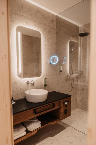 a bathroom with a sink and a mirror at Hotel Neubergerhof in Filzmoos