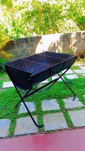 a black picnic table sitting on the grass at White Sky in Hikkaduwa