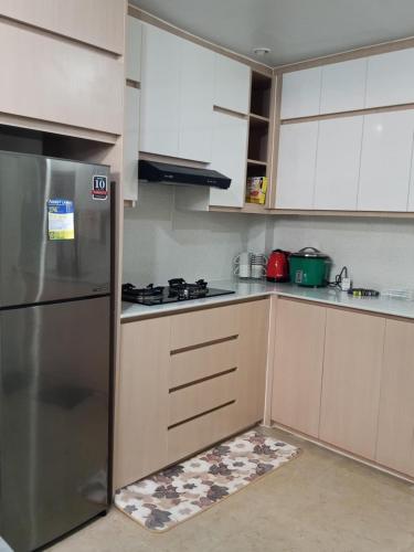 a kitchen with white cabinets and a stainless steel refrigerator at Welcome to Hambella home in Mactan