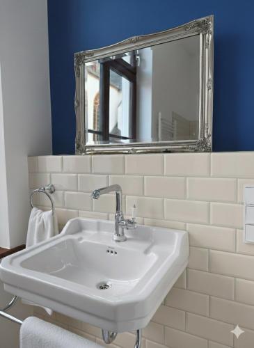 a bathroom with a white sink and a mirror at Karmeliterhof Studios & Suites in Boppard