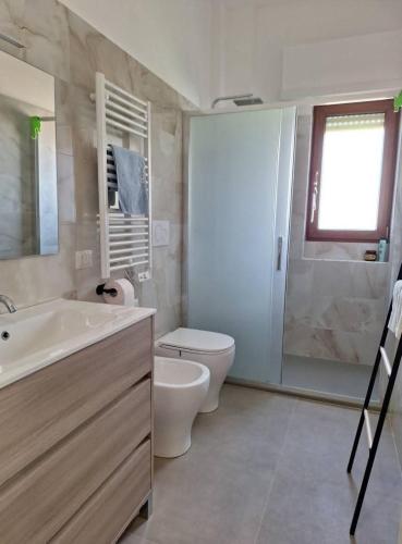 a bathroom with a toilet and a sink and a shower at My Sunset in Torvaianica