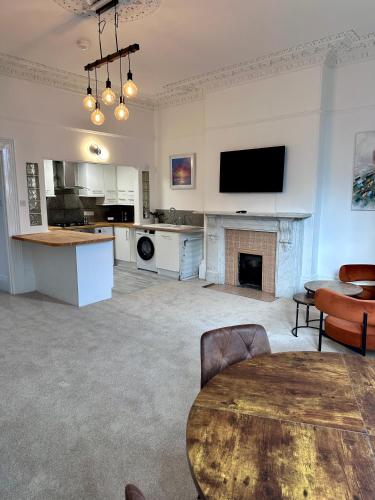 a living room with a table and a fireplace at Wilderness House Apartments by Smart Welcomes in Plymouth