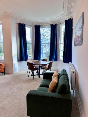 a living room with a green couch and a table at Wilderness House Apartments by Smart Welcomes in Plymouth