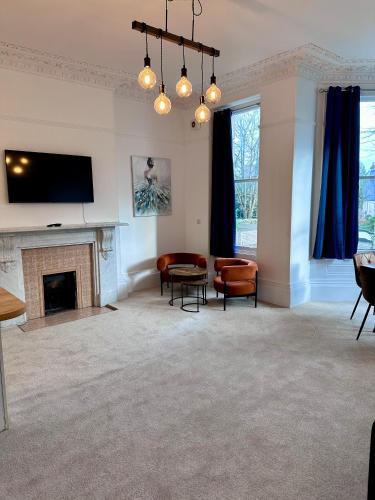 a living room with a fireplace and a flat screen tv at Wilderness House Apartments by Smart Welcomes in Plymouth
