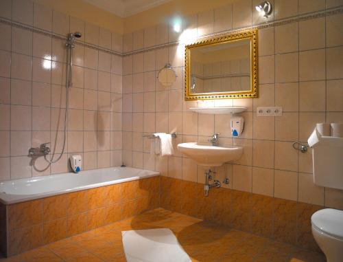 La salle de bains est pourvue d'une baignoire, d'un lavabo et d'un miroir. dans l'établissement Oldtimer Motel Pack, à Unterauerling