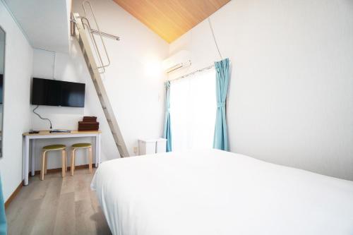 a bedroom with a bed and a desk and a tv at Mary's Room Sumiyoshi in Sumiyoshi