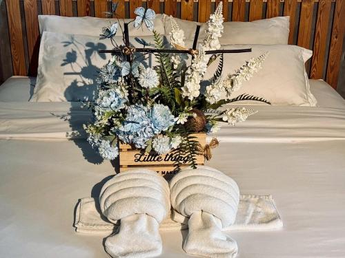 a bed with two towels and a vase of flowers at Bangkok Phattanakan32 guest house in Bangkok