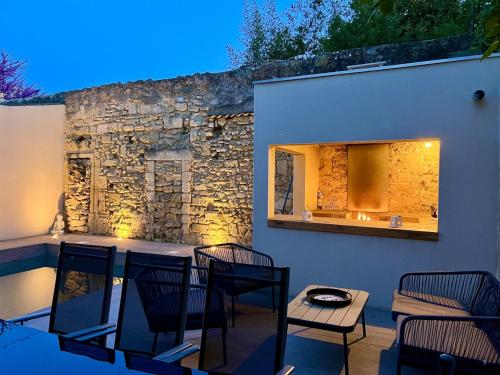 a patio with chairs and a table and a mirror at Cocon en petite Camargue in Aimargues