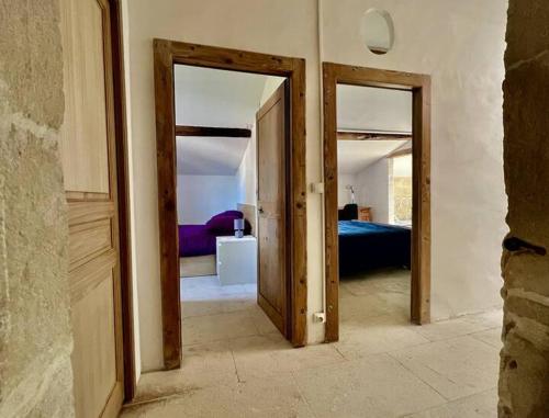a room with two open doors and a bedroom at Cocon en petite Camargue in Aimargues
