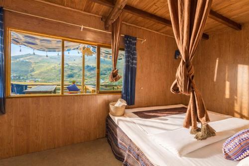 a bedroom with a bed with a large window at PaoDzung Homestay Sapa in Sapa