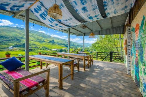 a group of tables and benches on a deck with a view at PaoDzung Homestay Sapa in Sapa