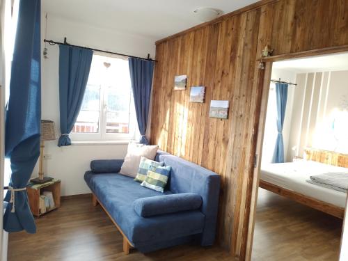 a living room with a blue couch and a bed at Kornihof in Waidhofen an der Ybbs