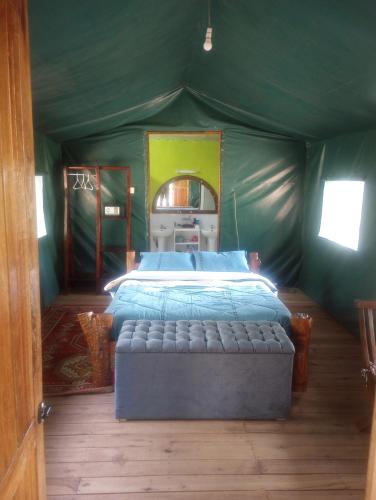 a bedroom with a bed in a green tent at Sirimon Base Camp in Nanyuki