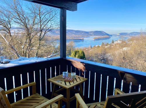 a balcony with a table and chairs and a view of the water at Szegfű33 Vendégház in Zebegény