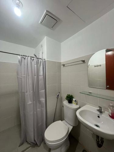 a white bathroom with a toilet and a sink at Hailey's Place Unit 2 in Bacolod