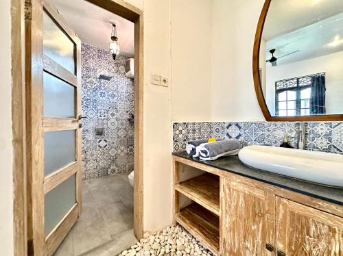 a bathroom with a sink and a mirror at Casa Sessy Legian in Seminyak