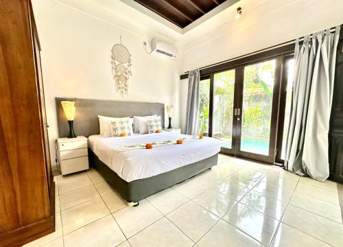 a bedroom with a bed and a large window at Casa Sessy Legian in Seminyak