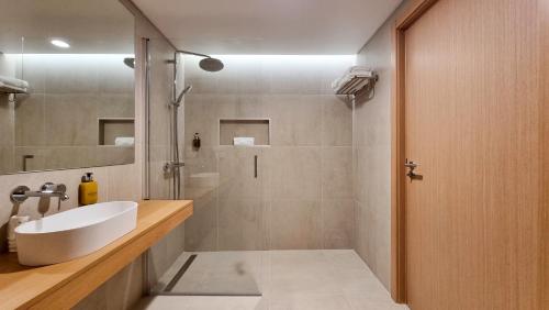 a bathroom with a white sink and a shower at Steyler Fatima Hotel & Congress in Fátima