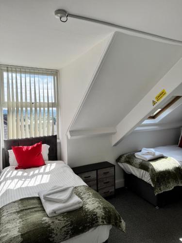 a bedroom with two beds and a red pillow at Wilderness House Apartments by Smart Welcomes in Plymouth