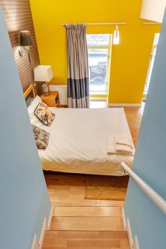 a bed in a room with a yellow wall at Royal Mile Apartments by Joivy in Edinburgh