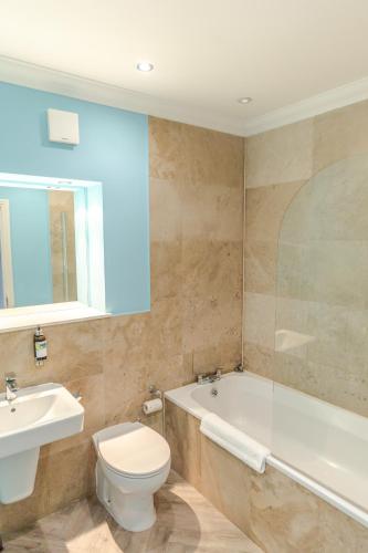 a bathroom with a tub and a toilet and a sink at Royal Mile Apartments by Joivy in Edinburgh