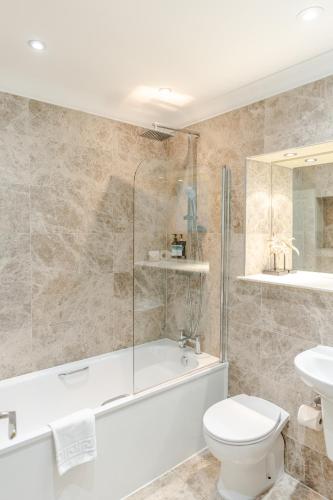 a bathroom with a tub and a toilet and a sink at Royal Mile Apartments by Joivy in Edinburgh