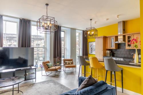 a kitchen and living room with yellow walls at Royal Mile Apartments by Joivy in Edinburgh