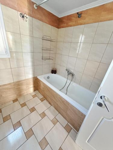 a bathroom with a tub and a tiled floor at Spacious 3bd Apartment in Lefkakia, Nafplio in Levkákia