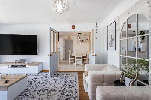 a living room with a couch and a tv at Matahari Apartments and Villas in Upper Hutt