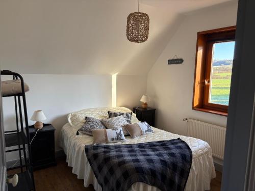 a bedroom with a bed with pillows and a window at Gîte LA ROUCHERIE bis in Lottinghen