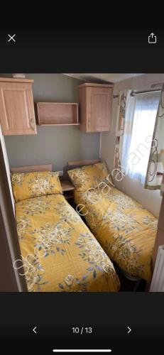 a small room with two beds and a window at 162 Northfield, 3 bedroom, 8 berth in Beeford