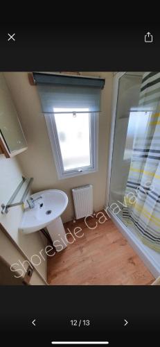 a bathroom with a sink and a window at 162 Northfield, 3 bedroom, 8 berth in Beeford