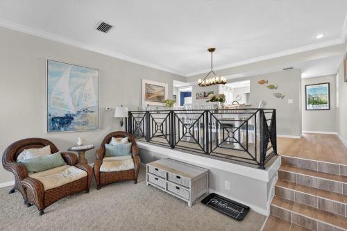 a living room with two chairs and a staircase at Coastal Lakehouse Condo on Siesta Key Public Beach in Sarasota