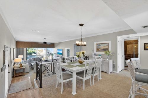 a dining room and living room with a table and chairs at Coastal Lakehouse Condo on Siesta Key Public Beach in Sarasota