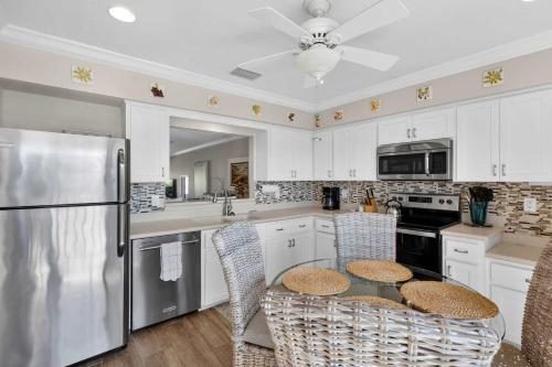 a kitchen with a refrigerator and a table with chairs at Coastal Lakehouse Condo on Siesta Key Public Beach in Sarasota