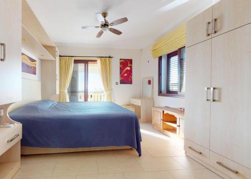a bedroom with a blue bed and a ceiling fan at Villa Magic Sunset in Kyrenia